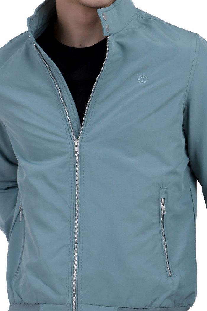 A cropped image of a man wearing an Aqua Blue Matt Finish Lightweight Jacket with high neck collar, zipper closure, and pocket in hand designed for casual winter layering and comfort.